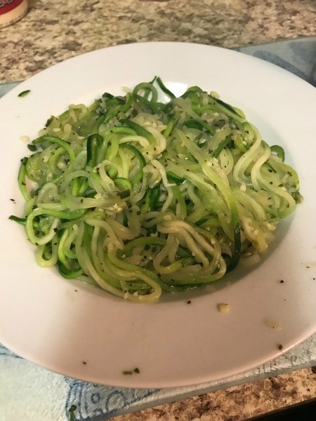 A plate of steamed zucchini spiral noodles.