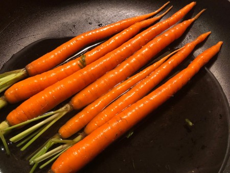 Whole carrots in a frying pan.