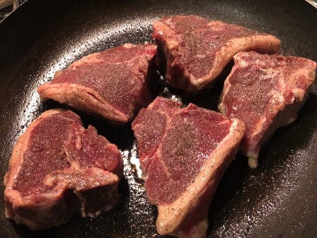 Lamb chops in a frying pan.