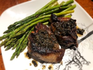 A plate of lamb chops with asparagus.