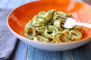A plate of tortellini with pesto.