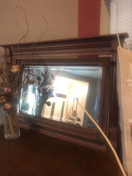A mirror on an antique dresser.
