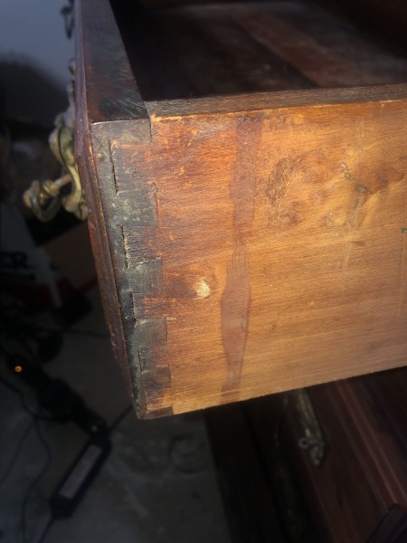 An open drawer of an antique dresser.