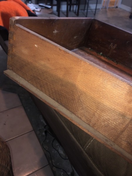 An open drawer of an antique dresser.