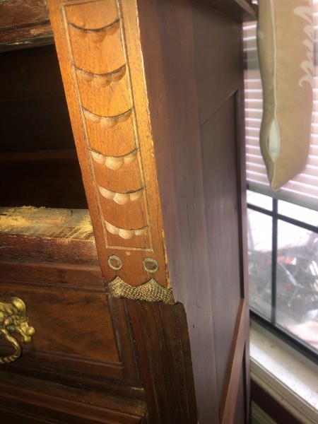 The side of an antique dresser.