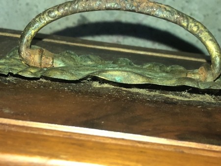 A metal pull on an antique dresser.