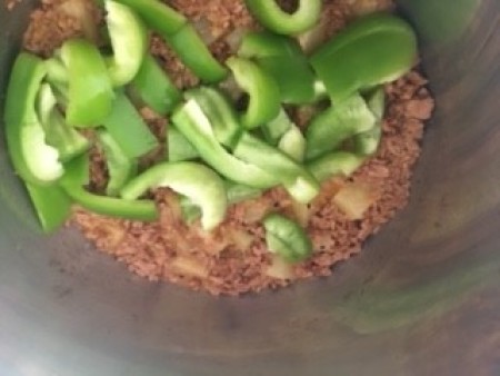 Adding green peppers to the TVP mixture.