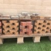 A low shelf on concrete blocks with other bricks stored above.