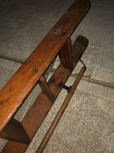 A wooden ladder with a handle on the side.