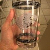 A drinking glass with silver markings.