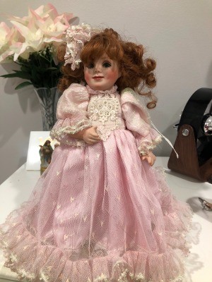 Identifying a Porcelain Doll? - doll wearing a pink lace and ruffle trimmed dress