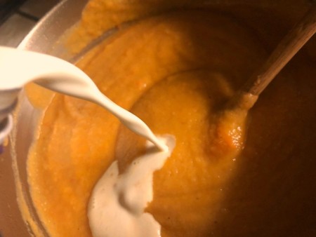 Adding milk to the stock pot.