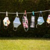 A collection of face masks hanging on a line.