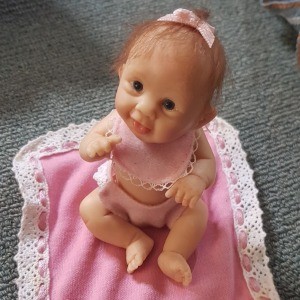 Value of Ashton-Drake Dolls? -baby doll on lace trimmed pink blanket