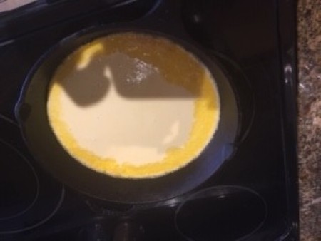 A cooking Dutch Baby in a pan.