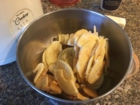 Sliced apples in a mixing bowl.
