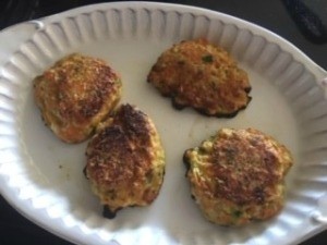 A plate with four vegetable fritters.