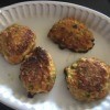A plate with four vegetable fritters.