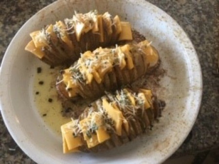 Potatoes with cheese between the slices.