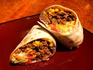 A super stuffed beef burrito cut in half.