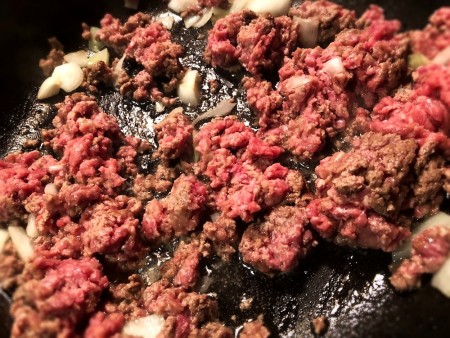Cooking ground beef in a frying pan.