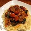 A plate of pasta topped with cherry tomato bolognese.