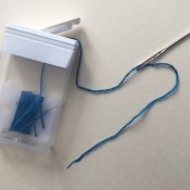 A Tic-tac container with embroidery floss stored inside.