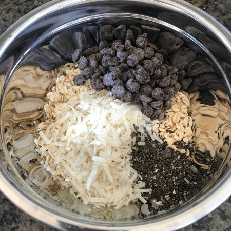 Adding ingredients for energy bites into a bowl.