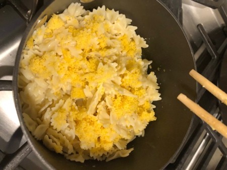 Adding cheese to the pasta.