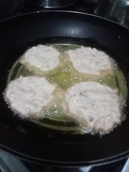 Frying the patties in a pan.