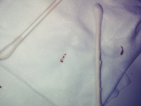 A small red smear next to two q-tips.