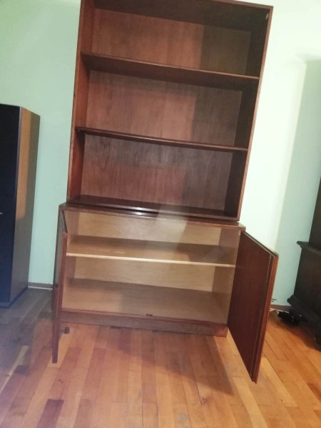 A teak bookshelf from the 1950s with a cabinet underneath.