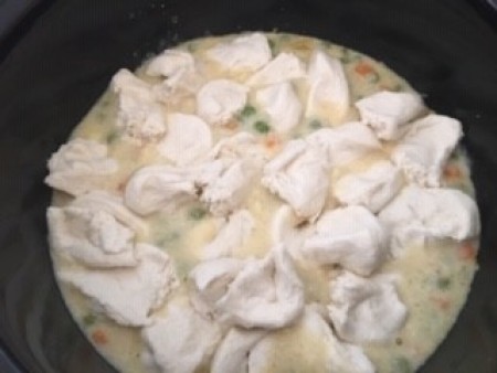 The crockpot full of cooked chicken pot pie ingredients.