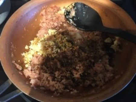 Combining the onions and garlic to a pan.