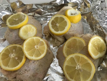 Lemon slices on top of chicken pieces.