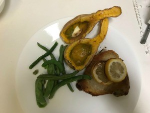 A plate of baked chicken with veggies.