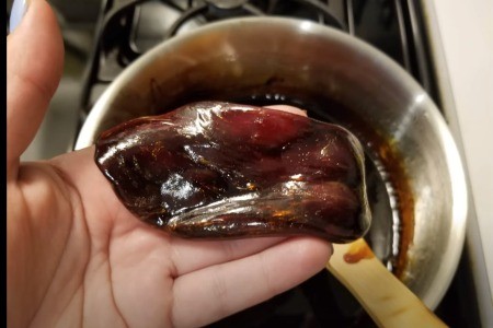 A dollop of sugar wax in a hand, ready for use.