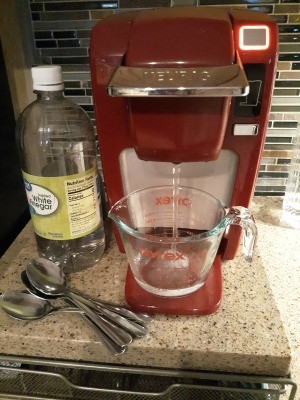 Vinegar and water in front of a Keurig coffee machine.