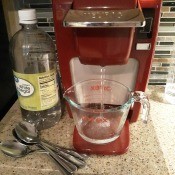 Vinegar and water in front of a Keurig coffee machine.