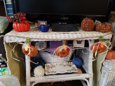 Mini Baking Tin Pumpkins - hanging across the front of a wicker table