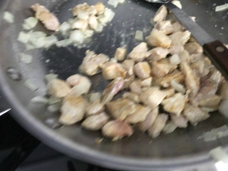 Cooking the chicken in a frying pan.