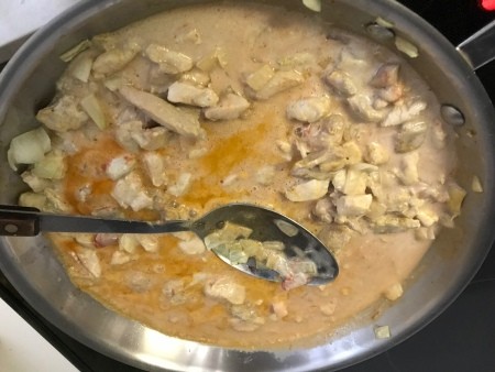A pan of chicken with curry sauce.