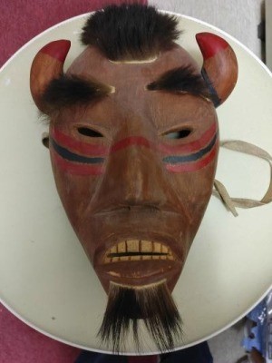 Painted mask with fur and horns.