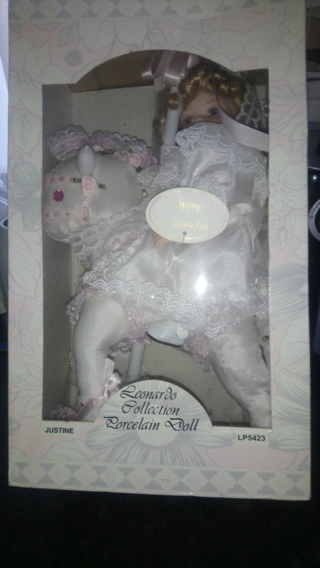A porcelain doll in a box.