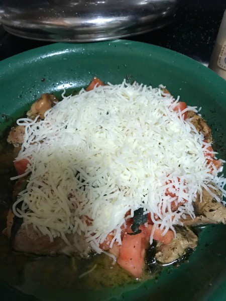 Adding grated cheese to the pan.