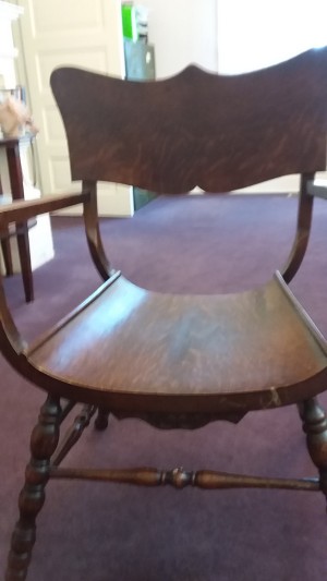 A wooden chair with a rounded seat.