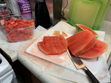 Cutting the watermelon into chunks.