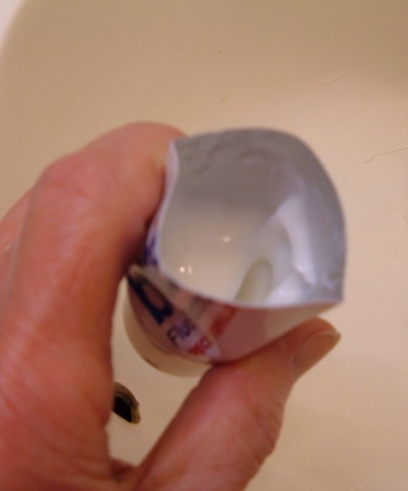 An open cut tube of toothpaste with several more servings inside.