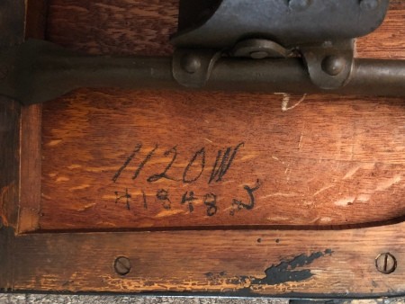 Numbers on the underside of a wooden chair.