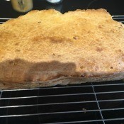 A loaf of pepperoni cheese bread on a cooling rack.